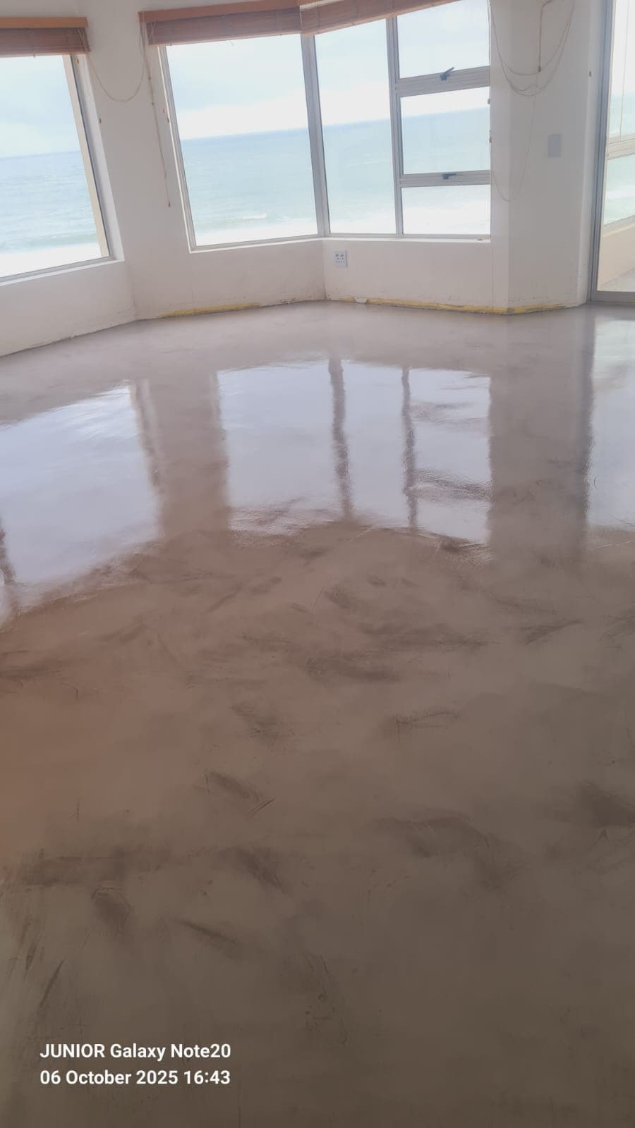 Seamless metallic floor in a sea-facing apartment by Junior Flooring