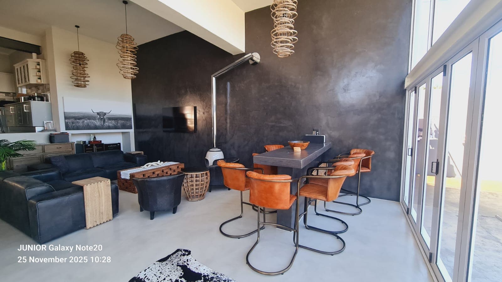 Living room with polished colour screed floor and plaster feature wall by Junior Flooring