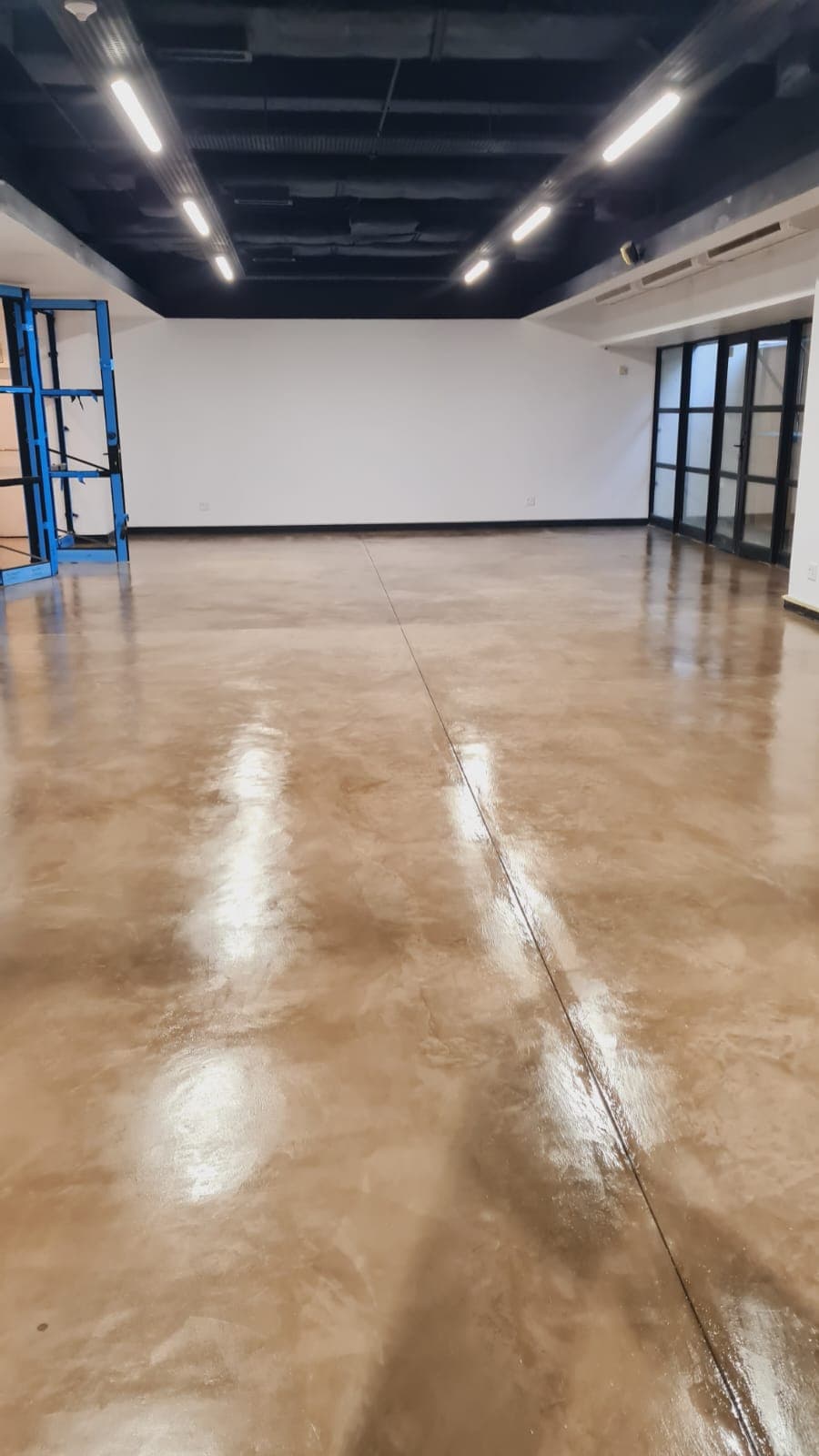 Glossy seamless metallic floor in a commercial space by Junior Flooring